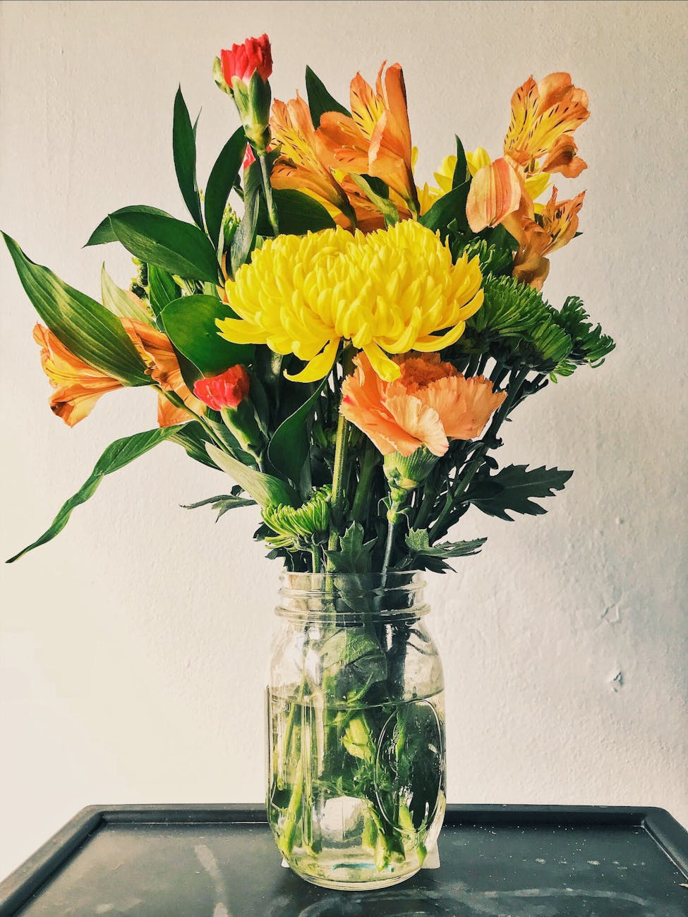 yellow mums orange peruvian lilies and carnation flower arrangement