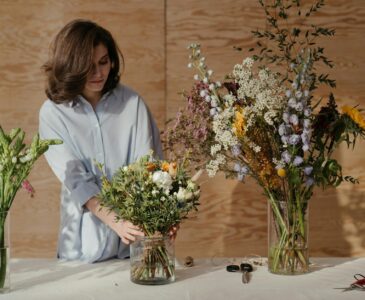 woman in white dress shirt holding bouquet of flowers