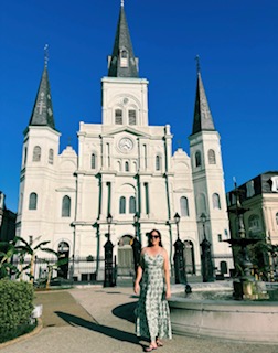 Woman standing in front of St. Louis Cathedral in New Orleans, LA.